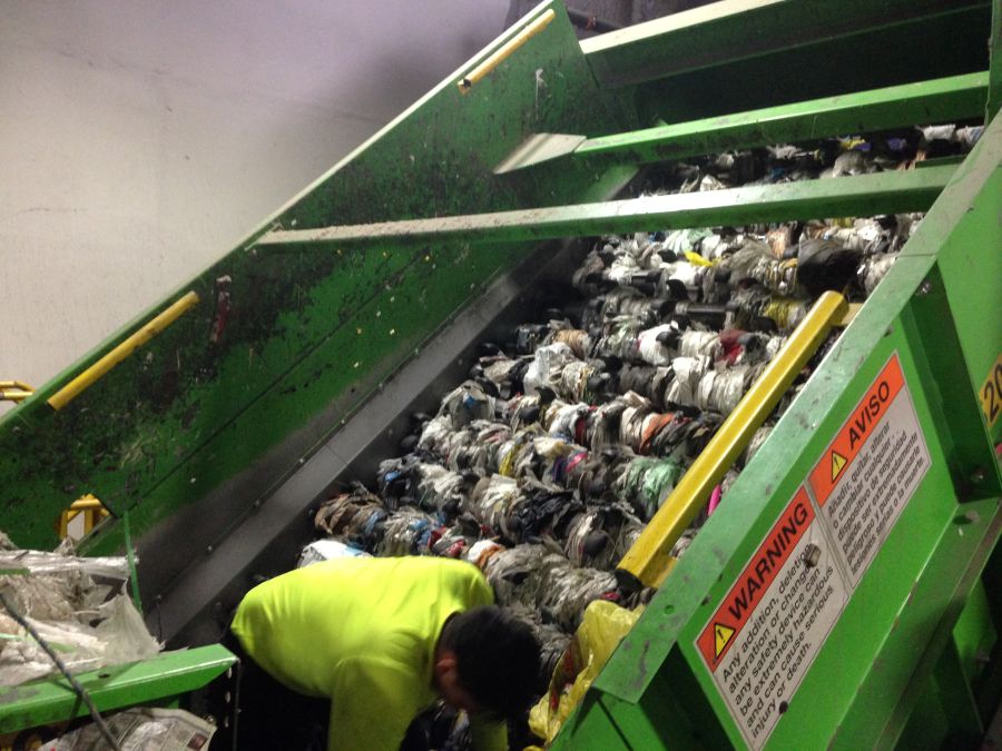 Man cutting plastic film that is wound around equipment rotors manually inside the machine.